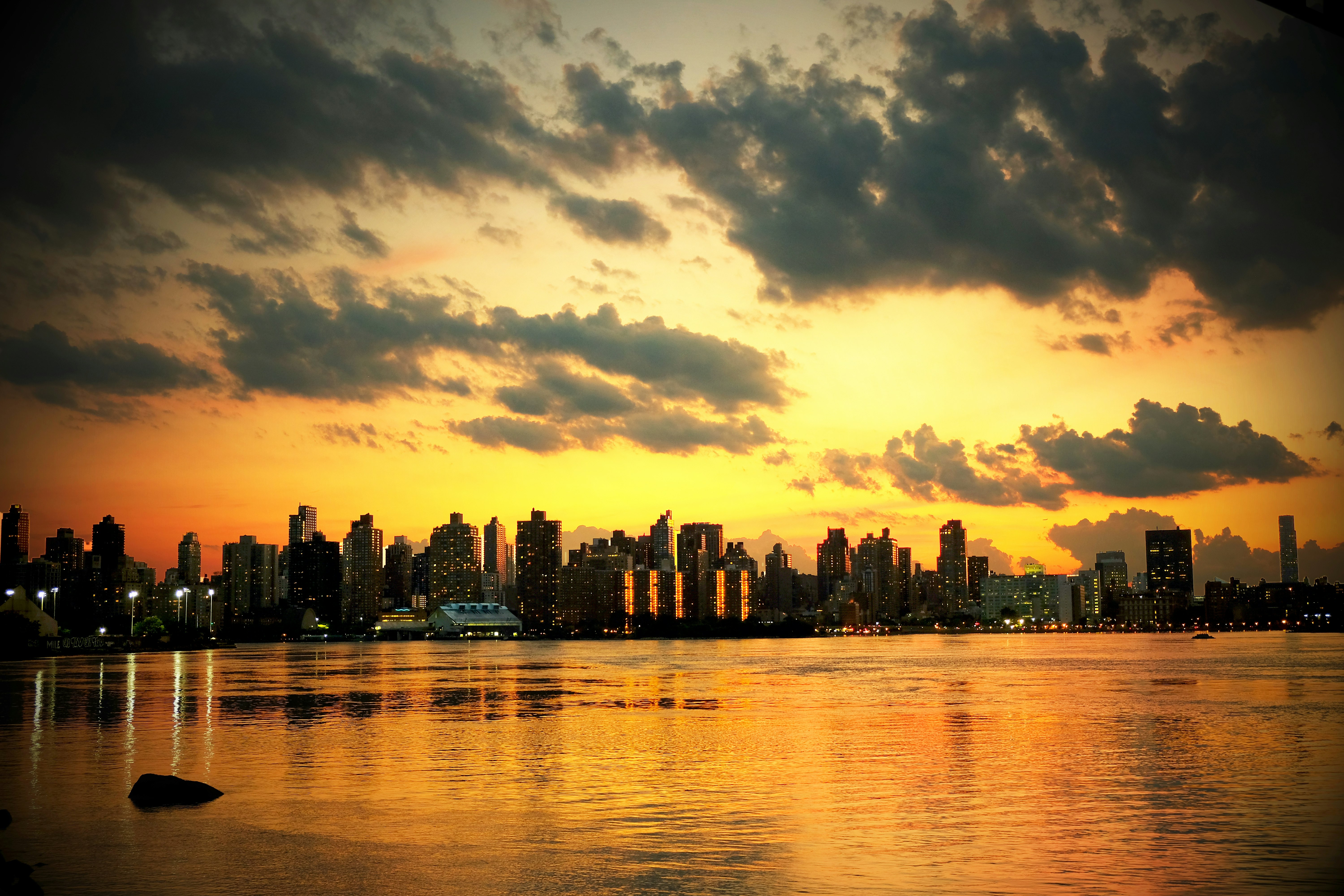 photo of cityscape under white clouds during golden hours